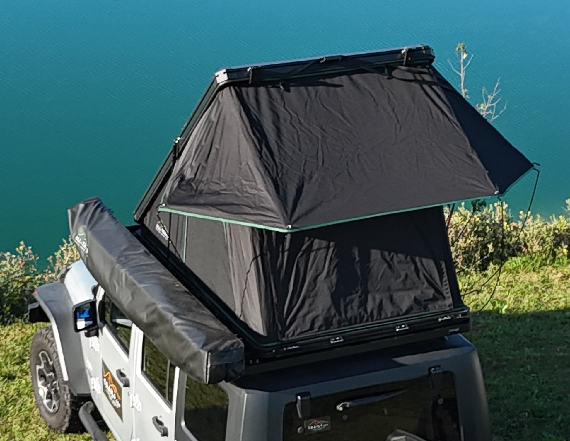 Black rooftop tent on a vehicle with a scenic background